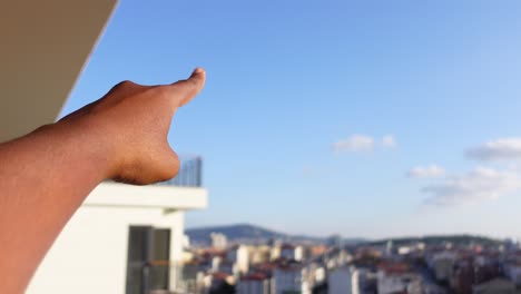 hand reaching towards the sky over city