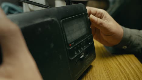 hand manually adjusts wave frequency on retro transistor radio dial