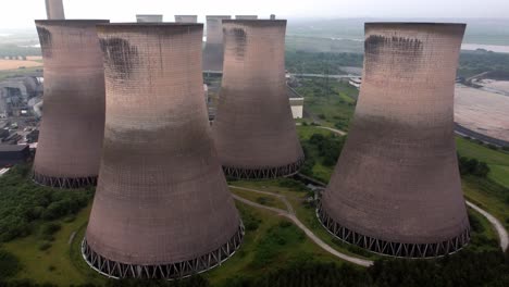 disused industrial energy power plant cooling smoke stake chimneys aerial view reversing