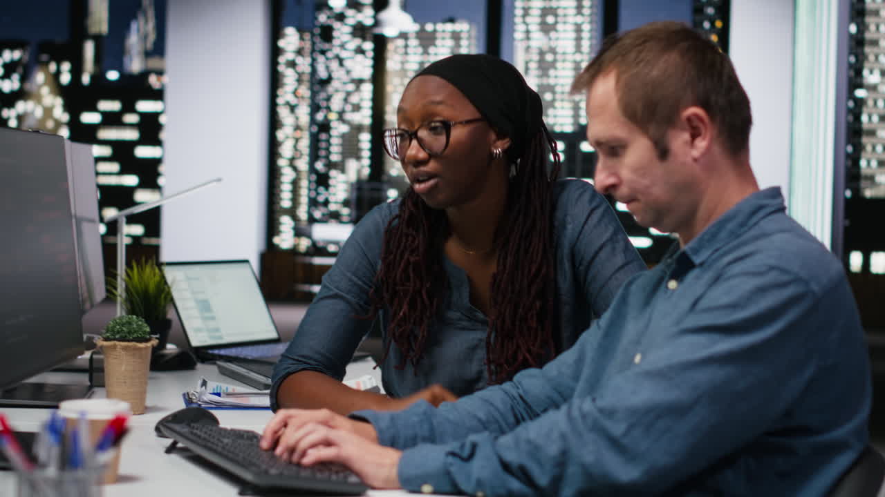Diverse Colleagues Collaborating on Software Development in Modern Office at Night