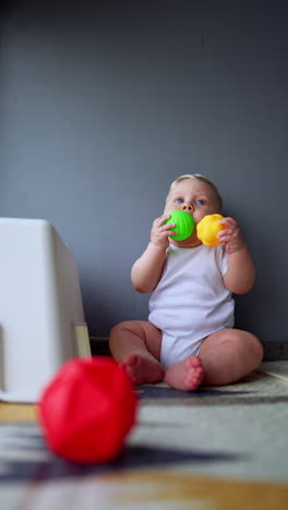 cute little newborn baby with colorful toys. adorable small kid. vertical video.