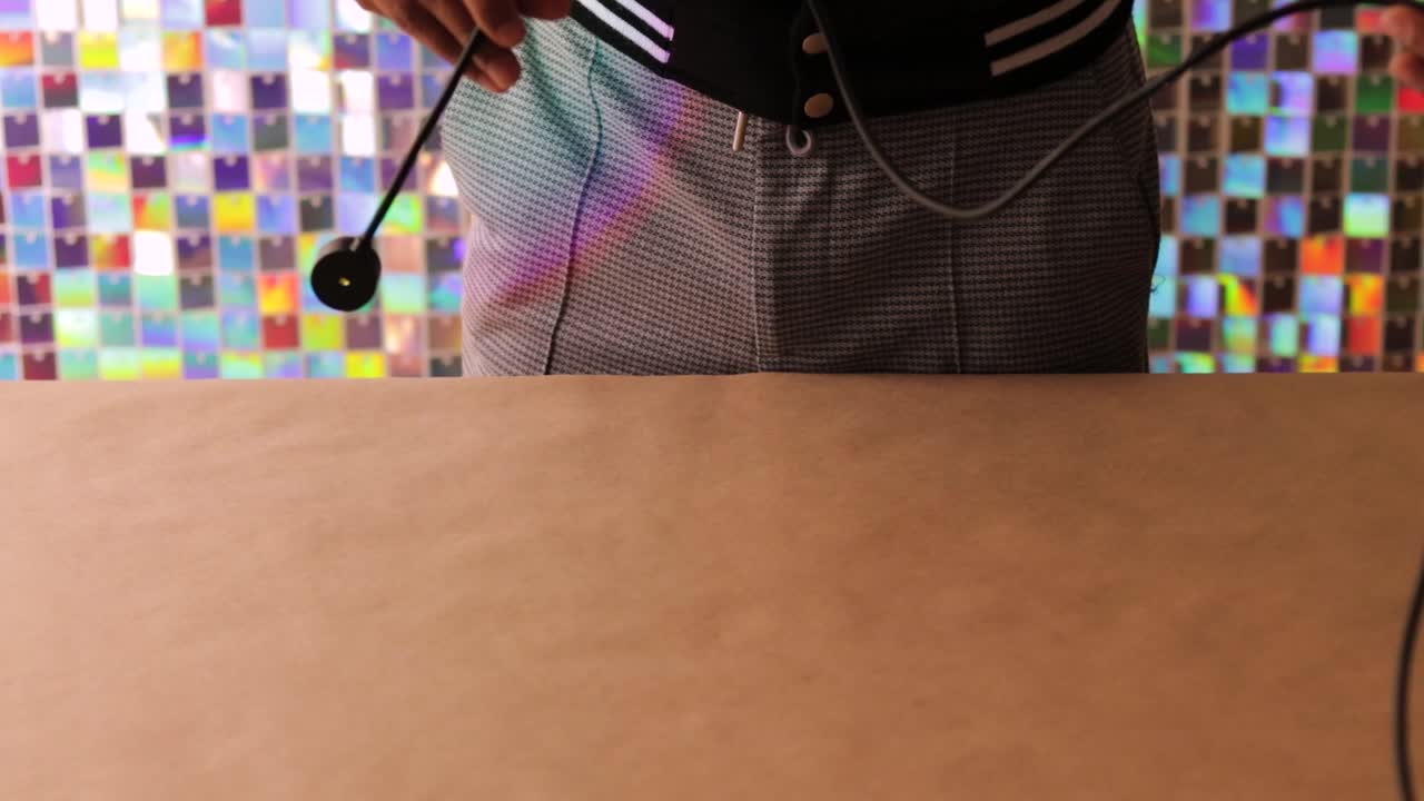 Person holds small USB light over plain table with colorful background reflections