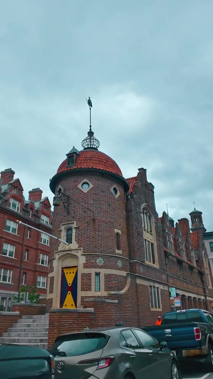 Boston, USA, 5. maj 2025: Historisk murstensbygning med gavle og buede vinduer i Boston. Lavvinkelbillede af murværksarkitektur fra det nittende århundrede med parkeringsskilte og biler i forgrunden.