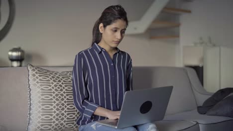 Serious-mix-raced-student-with-laptop-working