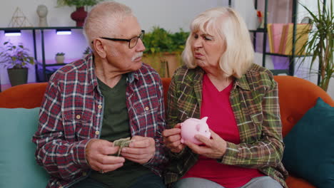 sad poor senior grandparents man woman counting money from piggybank, poverty debt financial problem