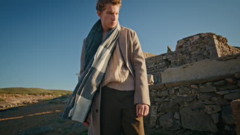 thinking man touching scarf resting windy nature closeup. guy walking nature