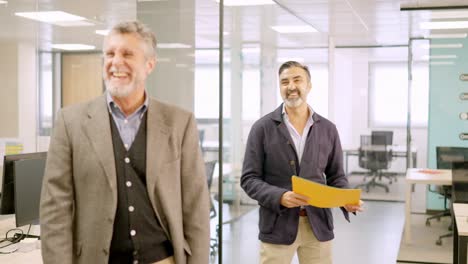 Two mature businessman smiling happily in a coworking office