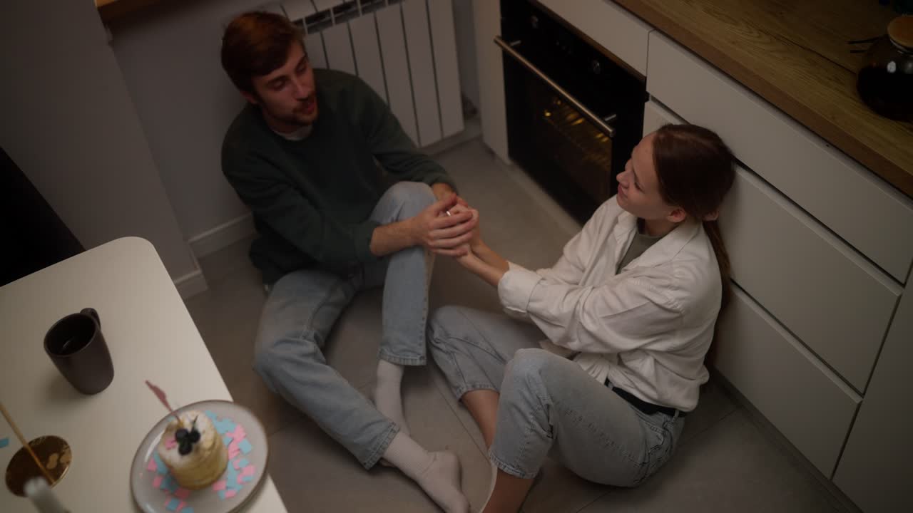 una pareja celebrando en la cocina.