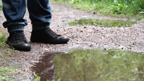 person walking through a muddy puddle