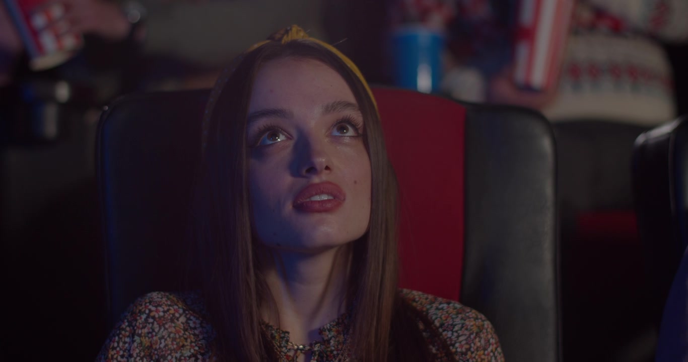 Young Woman Watching a Movie in a Cinema