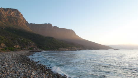 vagues sur le rivage rocheux de la plage avec la montagne des douze apôtres en arrière-plan à cape town, afrique du sud