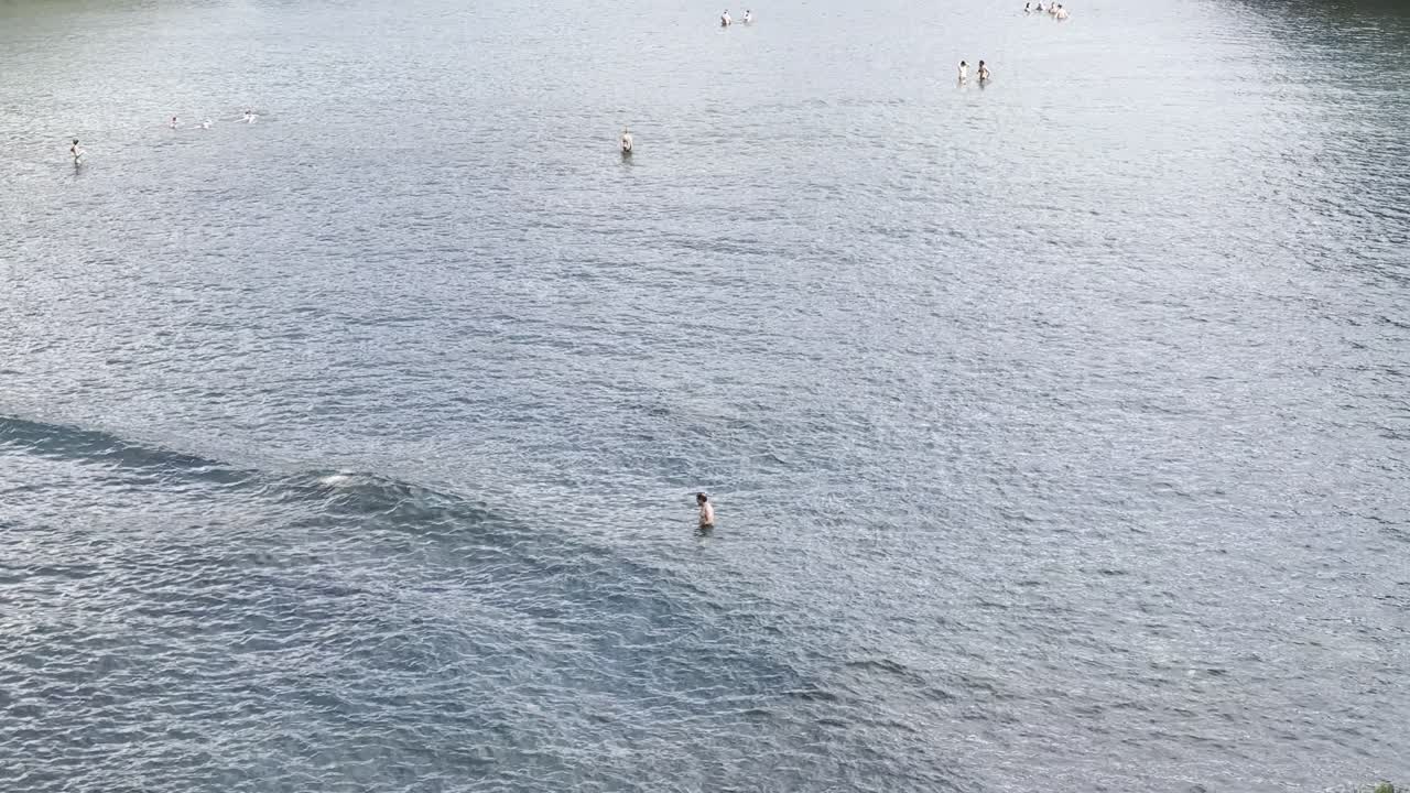 Beautiful Coastal Town with People Swimming in Calm Ocean Waters