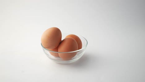 hand placing egg in a bowl