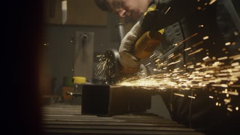 industrial worker cutting metal with many sharp sparks. male using special tool for cutting metal at workshop. sparks flying from metal processing. slow motion. 4k video. shot on red