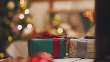 Tema-Navideño.-La-Mujer-Joven-Pone-Los-Regalos-Debajo-Del-árbol-De-Navidad.-En-El-Desenfoque.