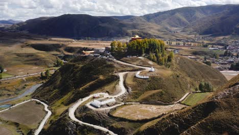 Drone-dolly-tilt-up-reveals-winding-road-to-Bamei-temple-in-Tibetan-Sichuan