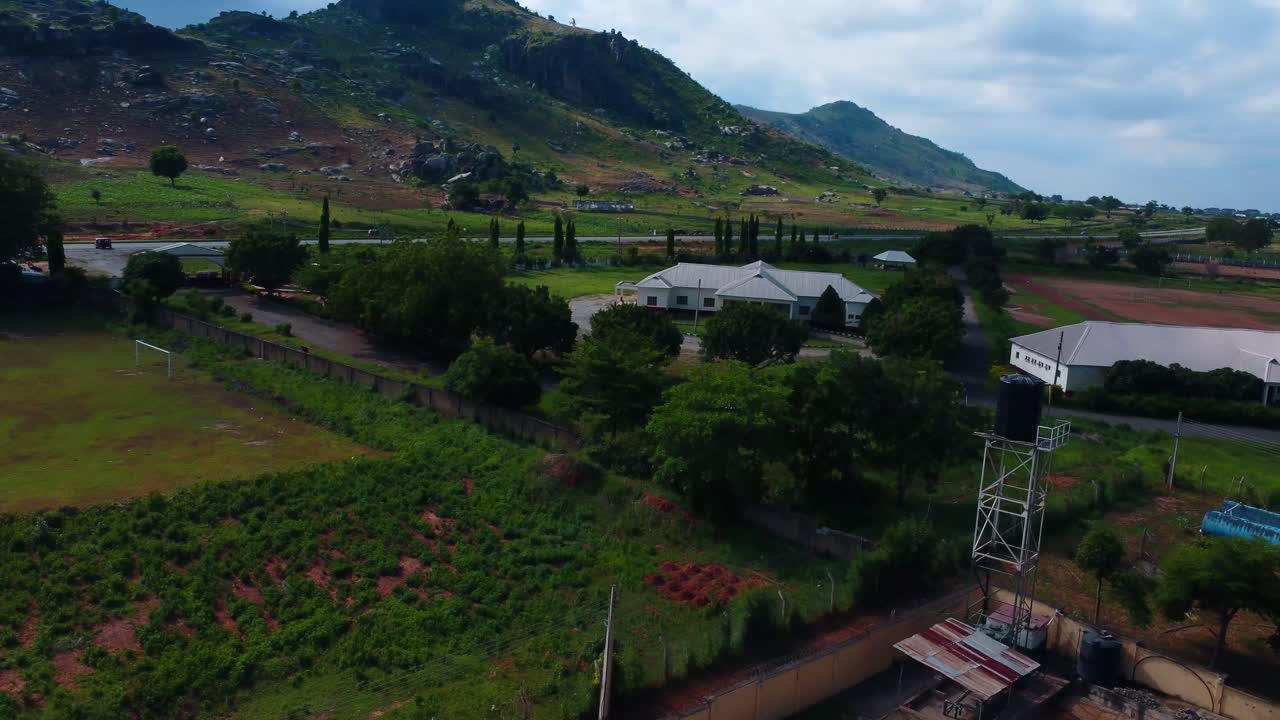 Establishing shot of SCC engineering site with rural landscape and cloudy sky. A construction company in Abuja, Nigeria