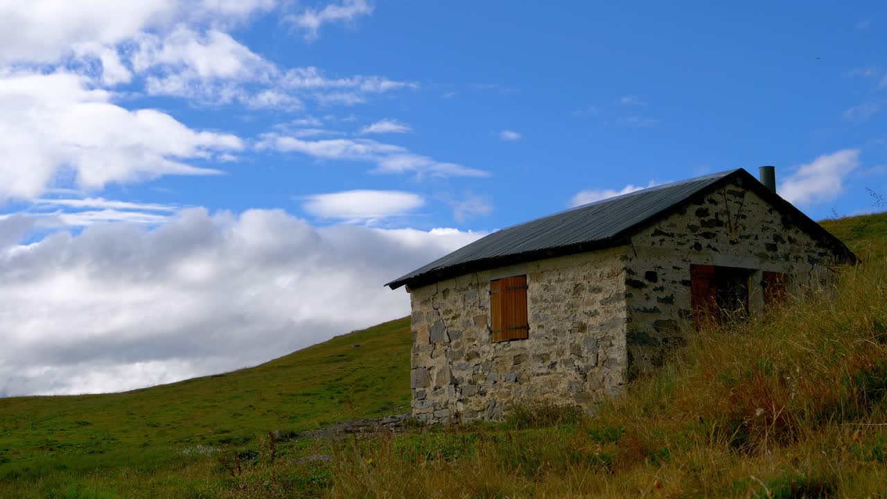 un hombre abriendo una ventana en un chalet aislado en las montañas