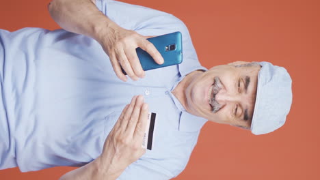video vertical de un anciano haciendo compras en el teléfono.