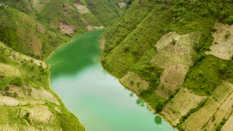 Gorgeous-turquoise-blue-green-water-surrounded-by-vast-lush-green-mountains-in-northern-Vietnam