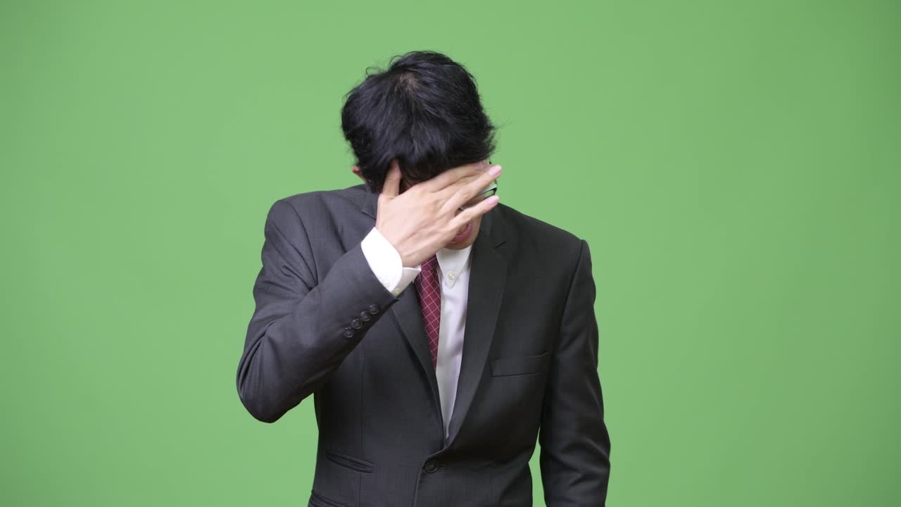 슬픈 젊은 아시아 사업가 전화를 사용하고 나쁜 소식을 얻습니다.