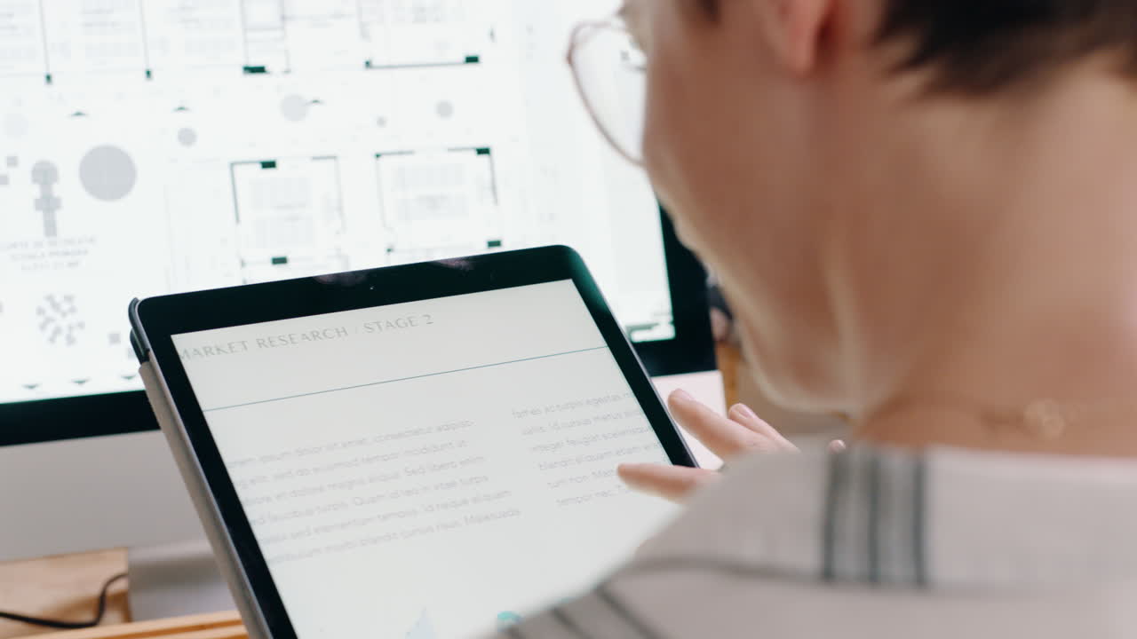 Kvinde bruger tablet til markedsundersøgelse med computer på kontor