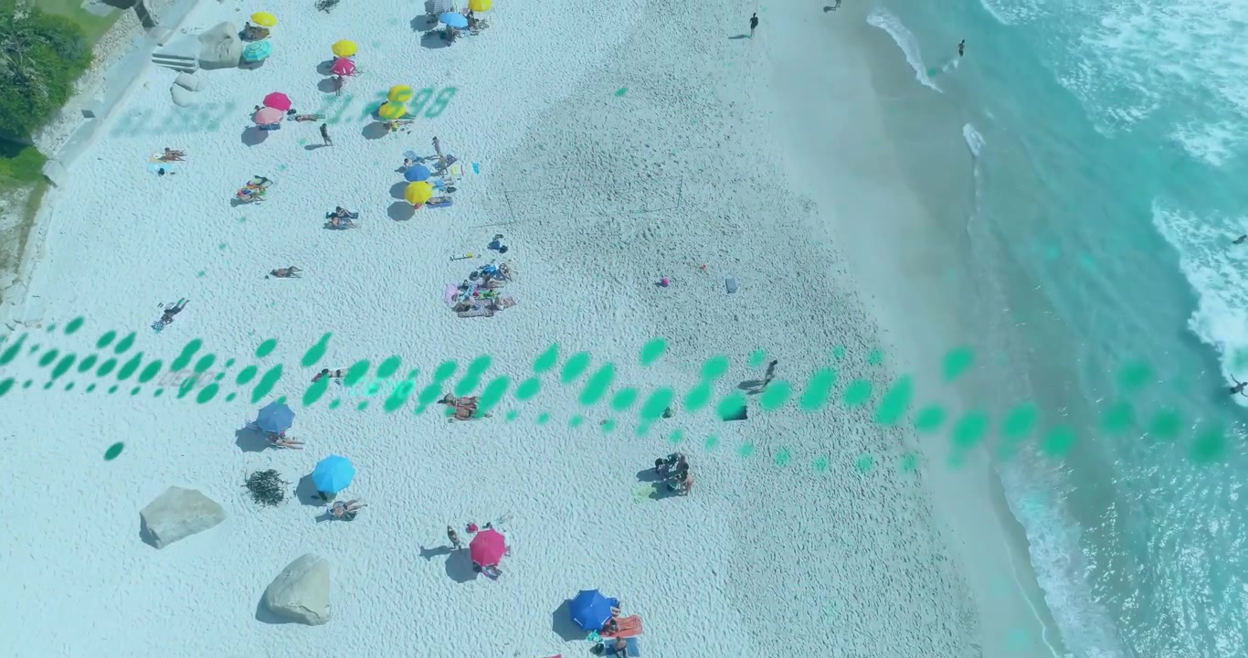 Vidéo verticale : Drone se déplaçant le long de la côte, une traînée venant de la gauche, suivant des parasols pour le voyage.