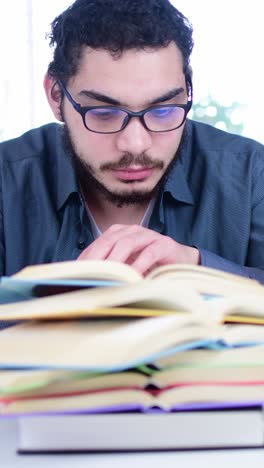 focused middle eastern student studying with books at desk