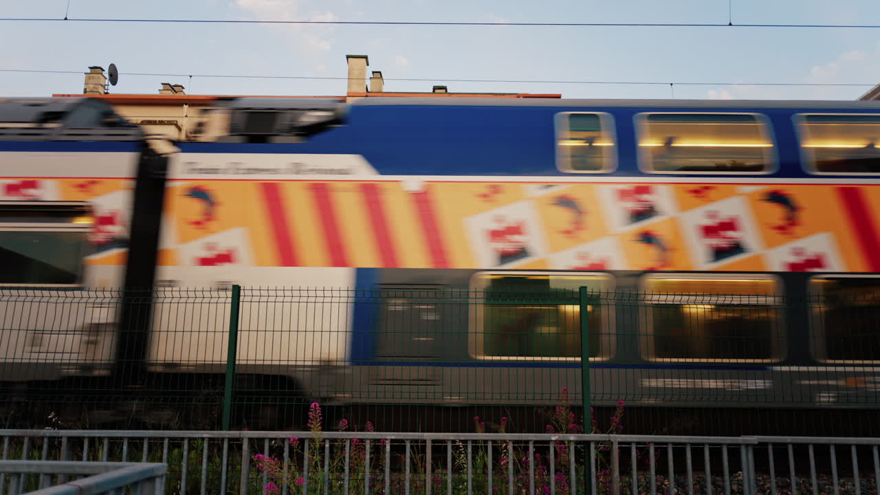 Antibes, France - May 23, 2025: Blue train passing near the beach in the evening