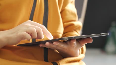 close up on the hand of caucasian woman pointing and touching the screen of tablet. technology social network and communication concept