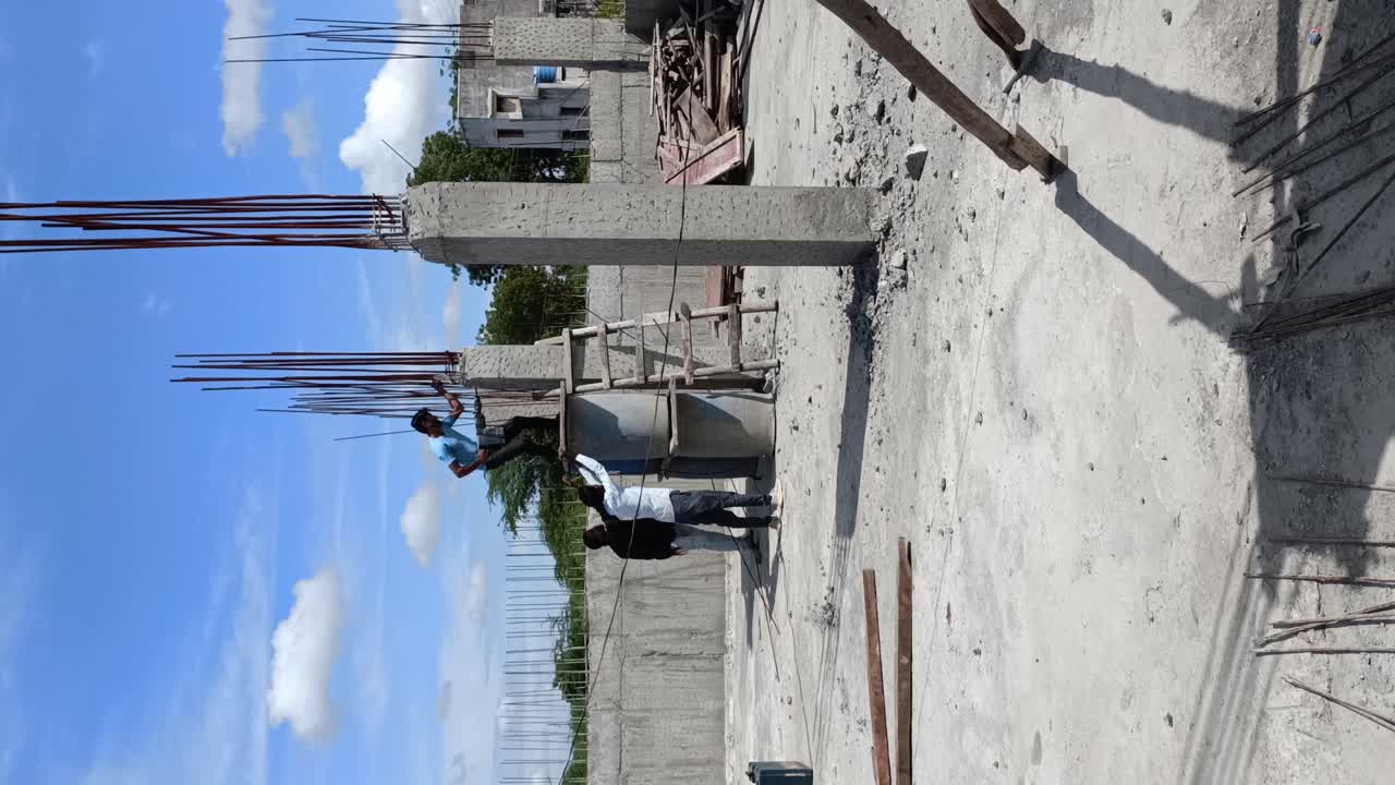 Aerial shot of the skeleton of an under construction multi story building in developing countryside.