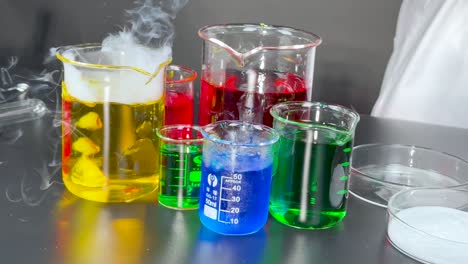 beakers with colorful liquids reacting and producing smoke