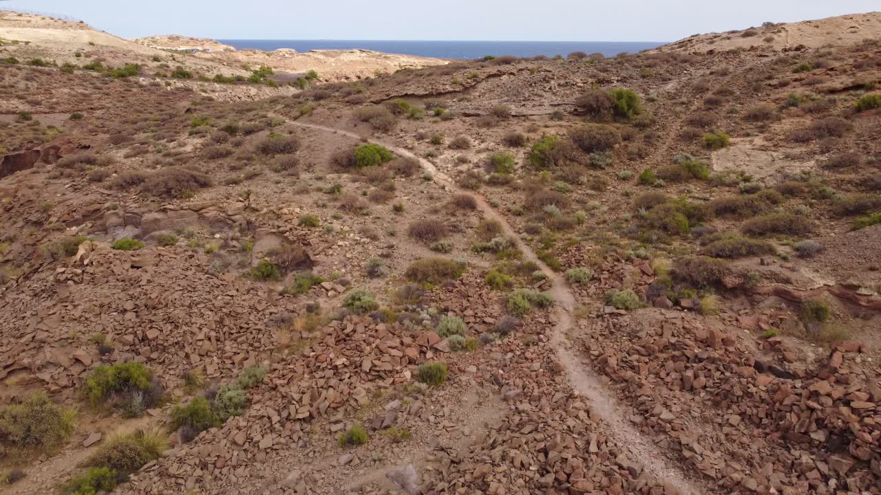Drone Retreats Over Sunlit, Arid Mountains by Tenerife&rsquo;s Sea