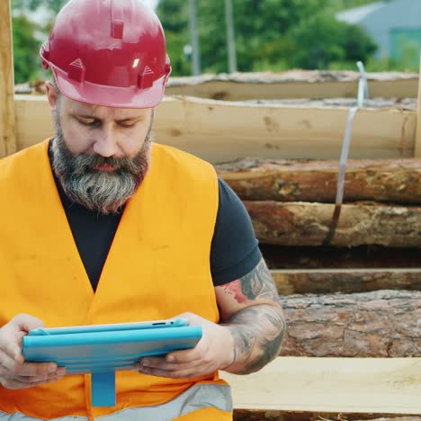 A-bearded-builder-in-a-helmet-uses-a-smartphone-2