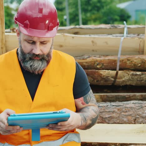 a bearded builder in a helmet uses a smartphone 2