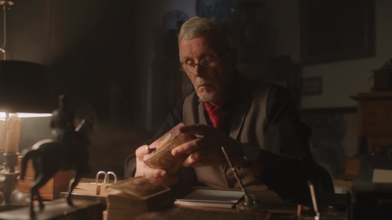 Older passionate man evaluates an old porcelain box