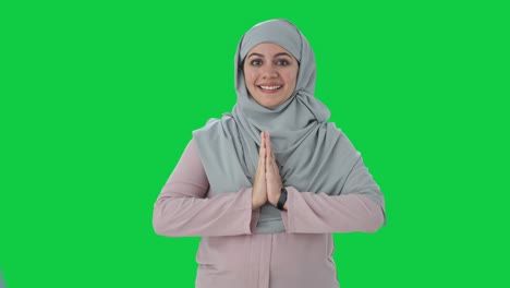 mujer de negocios musulmana feliz haciendo namaste pantalla verde