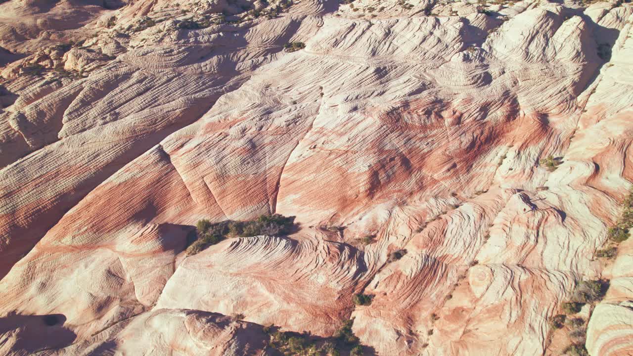 vista aérea de sobrevuelo de montañas de rayas naranjas y blancas en yant flats, utah cerca de st