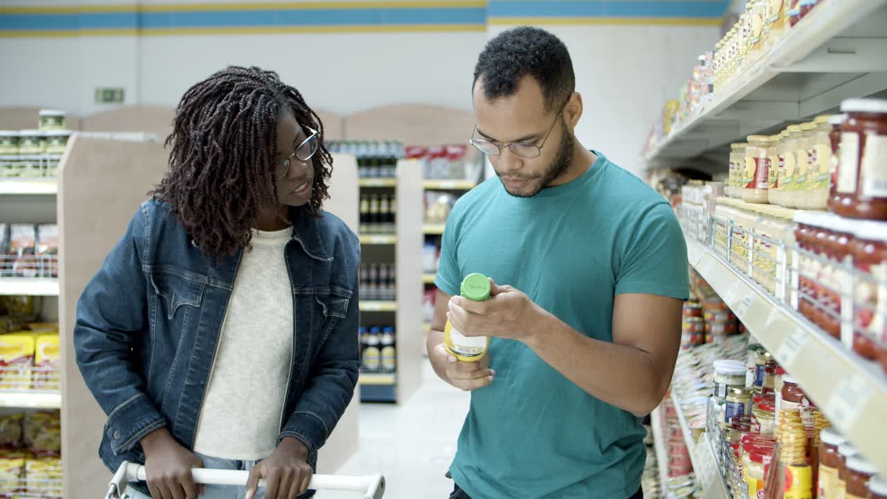 vista frontal de una joven pareja de compras en la tienda de comestibles