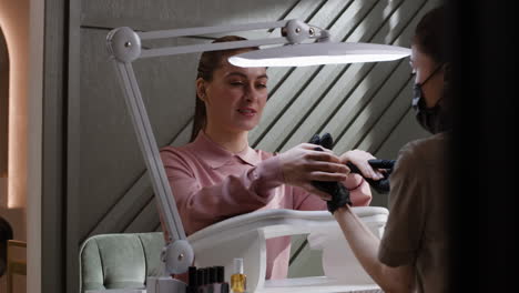 woman getting a manicure at a nail salon