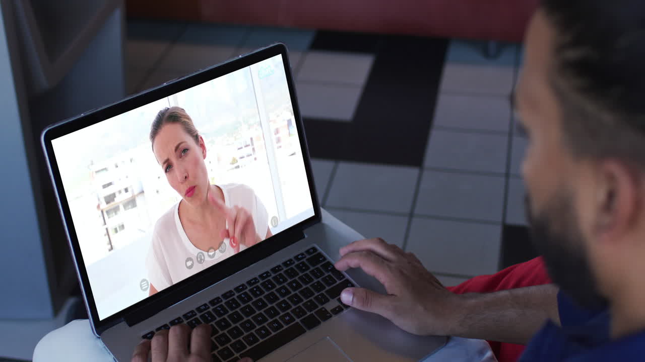 hombre afroamericano haciendo una videollamada con una colega de oficina en una computadora portátil en casa