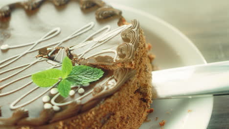 Closeup-piece-of-chocolate-cake-taking-with-knife-in-slow-motion.