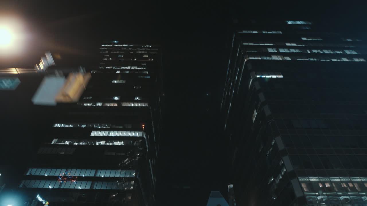 Low angle wide dynamic shot of reflections in high rise building at Night, Vancouver, Canada