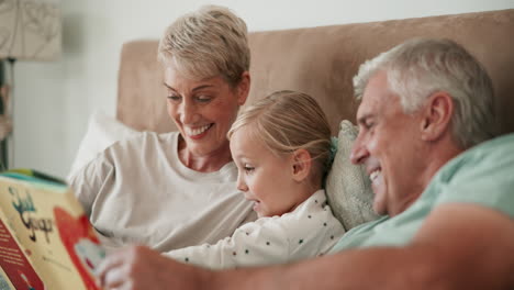 Cama,-Abuelos-Y-Niña-Leyendo-Un-Libro