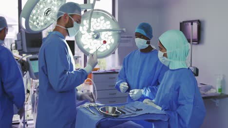 Side-view-of-Caucasian-surgeon-performing-operation-in-operation-theater