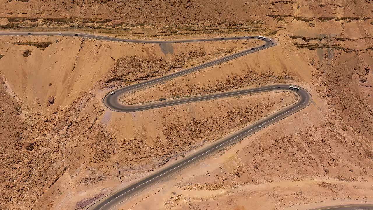 воздушный вид на дневной трафик, идущий вверх и вниз по пустынной горной извилистой дороге
