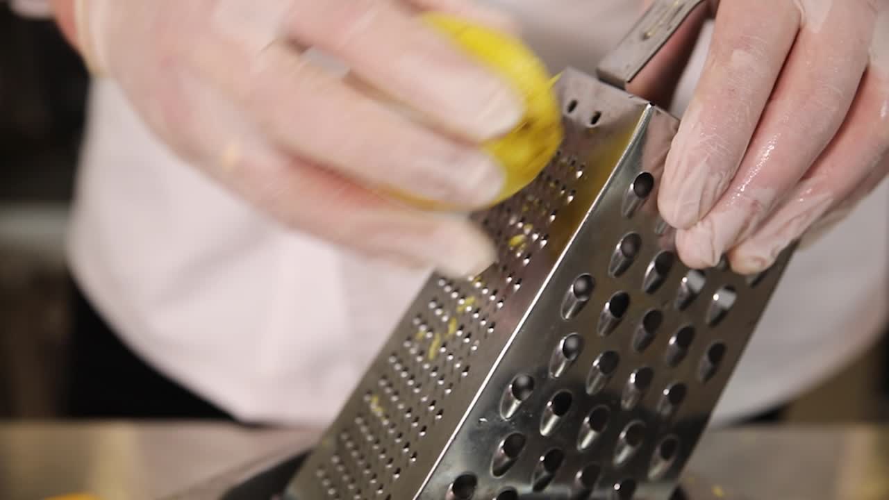 Chef che grattugia la scorza di un limone
