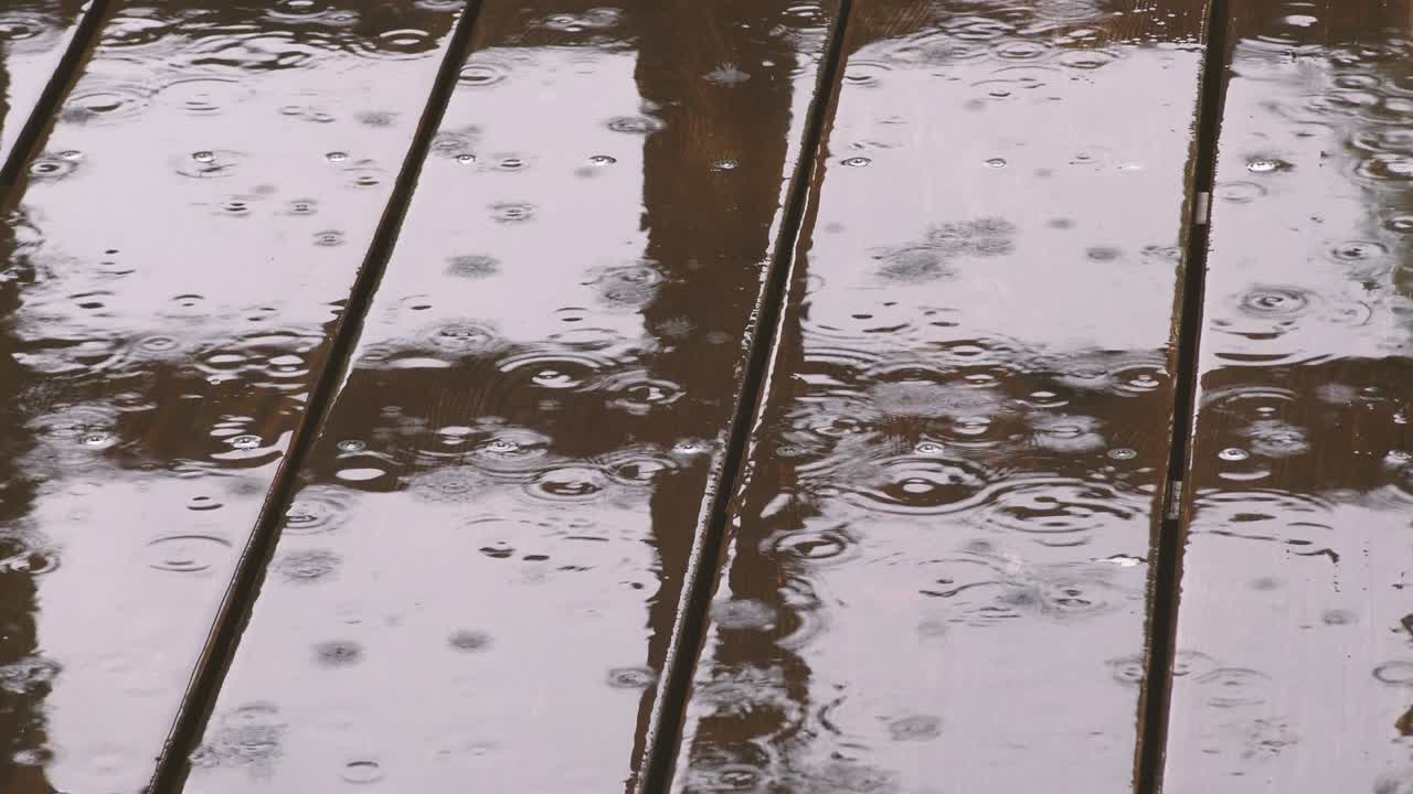 Background of rain drops falling on the wooden flooring.
