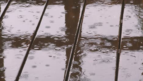 background of rain drops falling on the wooden flooring.