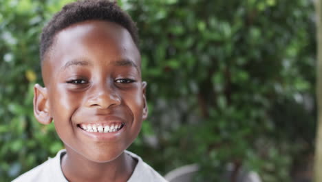 african american boy smiles brightly outdoors with copy space